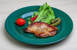 Roasted pork on the plate and wooden background photo