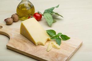 Parmesan cheese on wooden board and wooden background photo