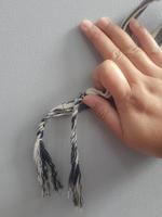 A hand is holding a cloth bracelet. photo