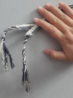 A hand is holding a cloth bracelet. photo