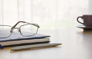 Glasses and book on the desk photo