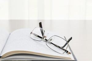 Eyeglasses put on a book with on the desk photo