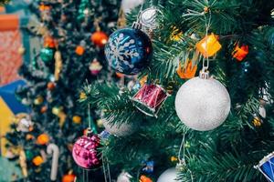 Decorated Christmas tree with colorful bauble on sparkling bokeh light blurred background photo