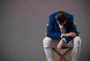 Sad man sitting in a chair and feeling depressed. photo