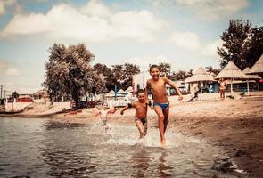 Carefree boys having fun in summer day at the beach. photo