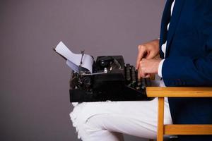 Unrecognizable man using typewriter. photo