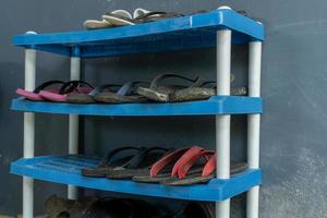 Plastic rack for shoes and sandals in front of the house. Blue sandal rack or shoe cabinet photo