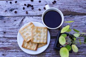 The hot black coffee in a white cup and the crackers are intense and go well together. photo