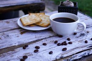 el café negro caliente en una taza blanca y las galletas son intensos y van bien juntos. foto