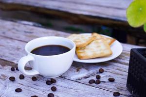 The hot black coffee in a white cup and the crackers are intense and go well together. photo