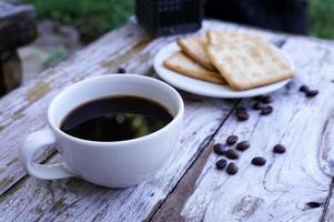 The hot black coffee in a white cup and the crackers are intense and go well together. photo