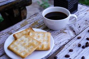 The hot black coffee in a white cup and the crackers are intense and go well together. photo