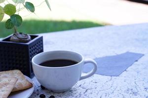 The hot black coffee in a white cup and the crackers are intense and go well together. photo