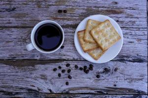 The hot black coffee in a white cup and the crackers are intense and go well together. photo