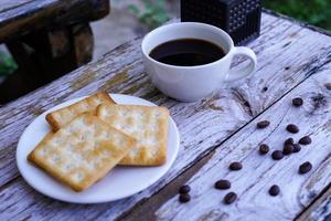 The hot black coffee in a white cup and the crackers are intense and go well together. photo