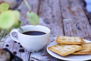 The hot black coffee in a white cup and the crackers are intense and go well together. photo
