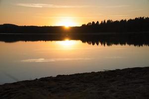 Sunset with reflection on a Swedish lake in Smalland. Romantic evening mood photo