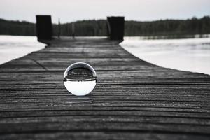 bola de cristal en una pasarela de madera en un lago sueco en la hora azul. naturaleza escandinavia foto