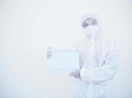 joven médico o científico con uniforme de suite ppe sosteniendo papel en blanco para texto con ambas manos mientras mira hacia adelante. concepto de coronavirus o covid-19 fondo blanco aislado foto