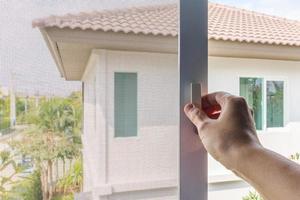 Hand hold mosquito net wire screen handle on house window photo