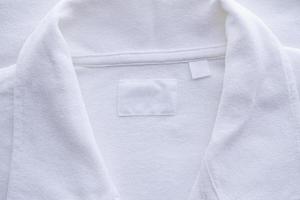 Blank white clothes label on new shirt background photo