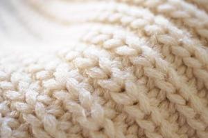 closeup beige knitted woolen fabric texture background photo