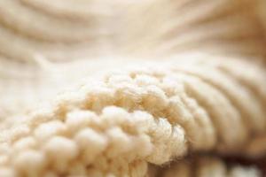 closeup beige knitted woolen fabric texture background photo