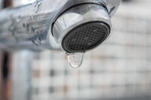 Close up faucet with water drop photo