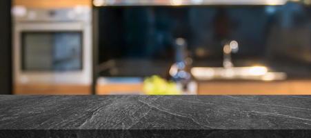 black marble stone counter top with blurred kitchen interior background photo