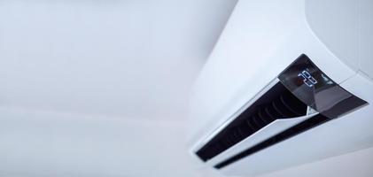 Air conditioner on white wall room interior background photo