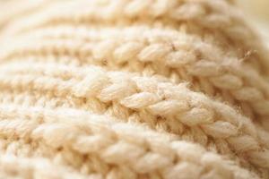 closeup beige knitted woolen fabric texture background photo