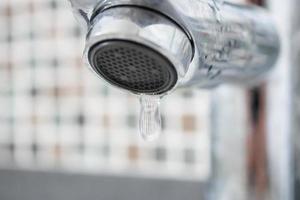 Close up faucet with water drop photo