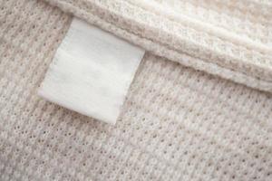 etiqueta de ropa blanca en blanco sobre fondo de camisa de algodón foto