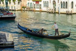 VENICE, ITALY - OCTOBER 12. Gondolier plying his trade on the Grand Canal Venice on October 12, 2014. Unidentified people photo