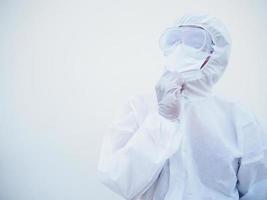 Portrait of confident asian male doctor or scientist in PPE suite uniform deep thinking creative person hand on chin with copy space for text or design on white background. COVID-19 concept. photo