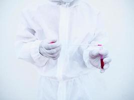 Asian doctor or scientist in PPE suite uniform. Personal protective equipment suit dropping a blood into blood test tube. coronavirus or COVID-19 concept isolated white background photo