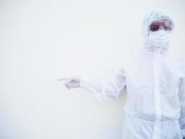 Asian male doctor or scientist in PPE suite uniform showing pointing fingers away at copy space while standing and looking forward. coronavirus or COVID-19 concept isolated white background photo