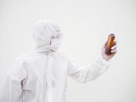 Portrait of doctor or scientist in PPE suite uniform holding plastic bottle with skin care product. COVID-19 concept isolated white background photo