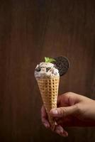 Sweet homemade ice cream with cookies in cone, selective focus photo