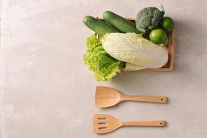 Fresh vegetables in wooden tray. Healthy food ingredients. Organic farmer vegetables. Top view. photo