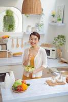 Young woman eating salad and holding a mixed salad . photo