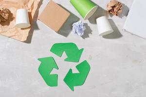 recycling symbol with waste on wooden background top view photo