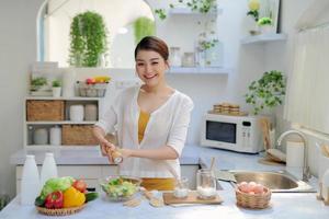 Woman putting salt in bowl. photo