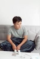 Man feeling cold, lying in the sofa and blowing his nose photo