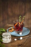 Cold ginger tea with orange and lemon in glass cups. Tea with sugar. The decor. Cinnamon and Rosemary Spices photo