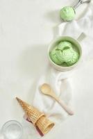 helado casero de aguacate orgánico, con conos de helado. en una mesa de piedra gris, copie el espacio foto