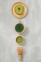 Matcha green tea latte in a cup and tea ceremony utensils with German cake. Copy space photo