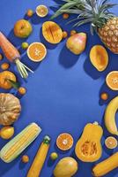 colección de frutas y verduras amarillas frescas en el fondo azul foto