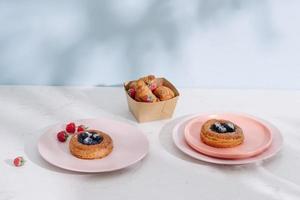 Tasty fresh homemade puff pastry with berries on the white wooden table photo