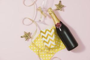 Clipboard and Bottles of champagne with golden decorations. Flat lay, top view trendy holiday concept. photo